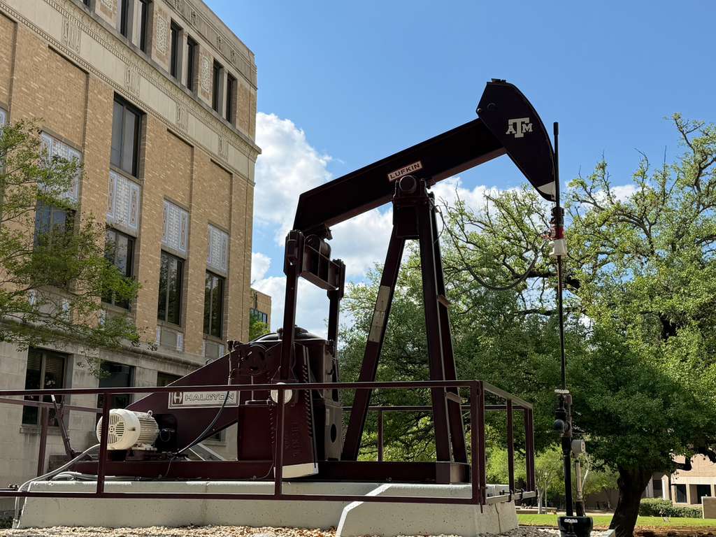 Maroon pumpjack on a university campus with Texas A&M branding